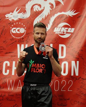 Thorsten Müller zeigt Silbermedaille vor roter Wand mit WM-Logo