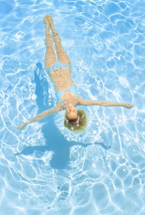 Eine Frau im Bikini badet in einem Pool